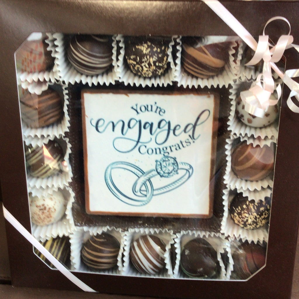 Box of chocolates with an 'Engaged' sign, likely for a wedding announcement.
